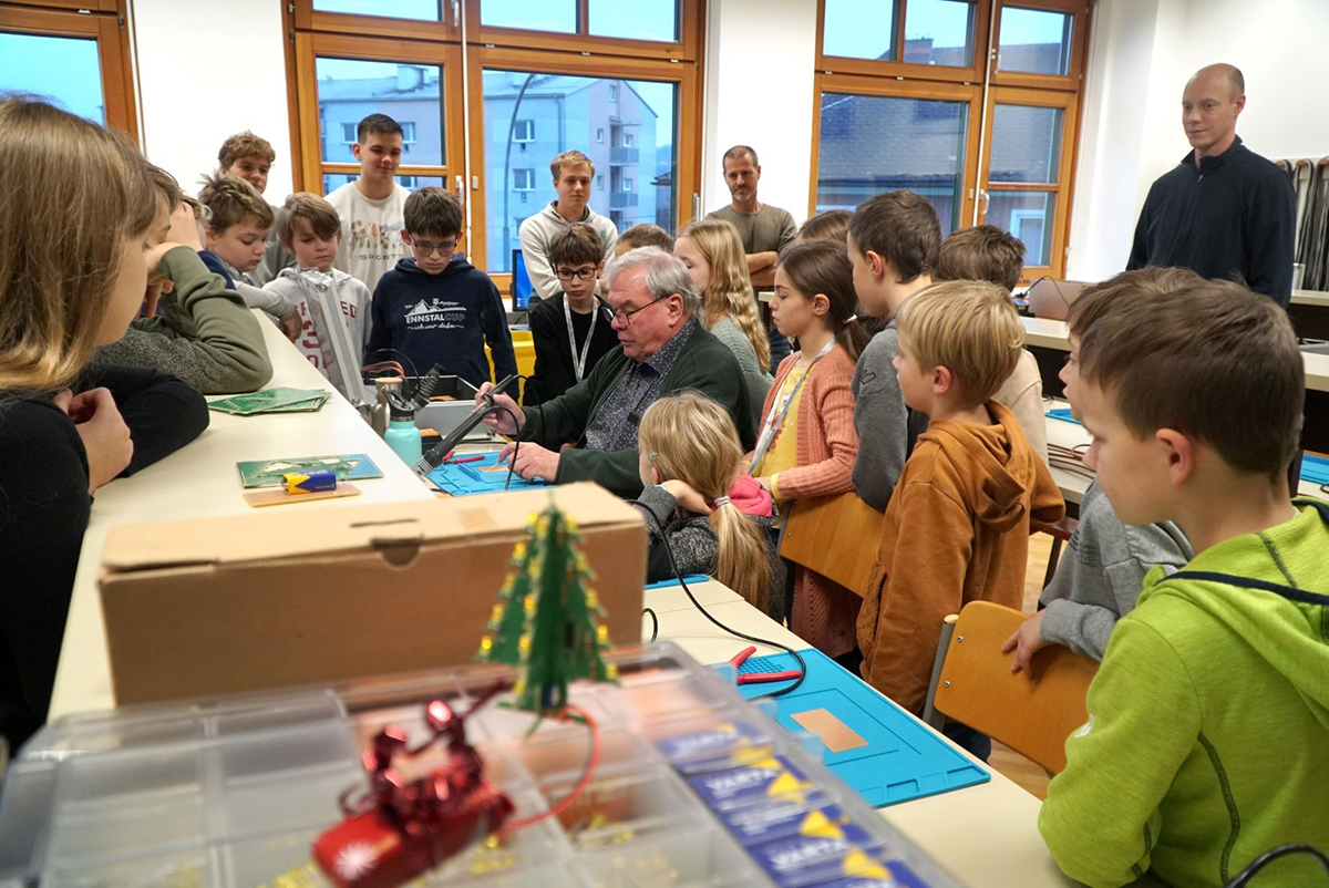 Alois Hofstätter zeigt den Kindern beim CoderDojo Steyr in der HTL Steyr wie gelötet wird.