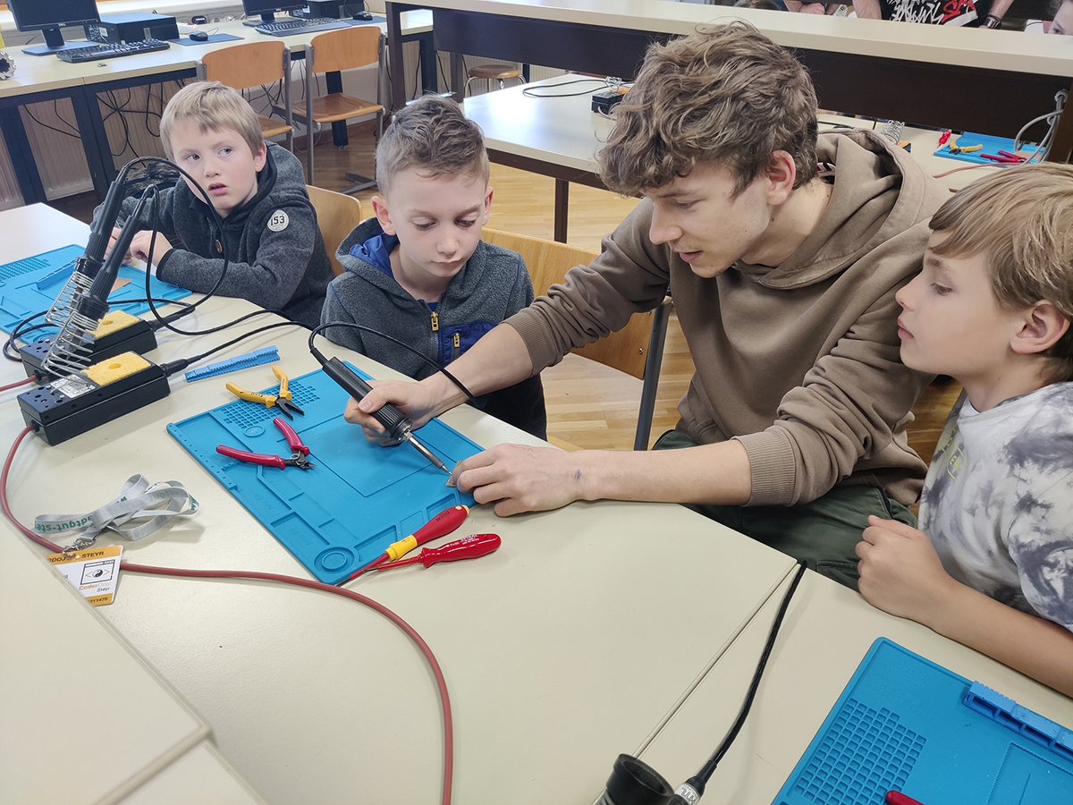 HTL-Schüler.innen helfen CoderDojo Kindern beim Löten