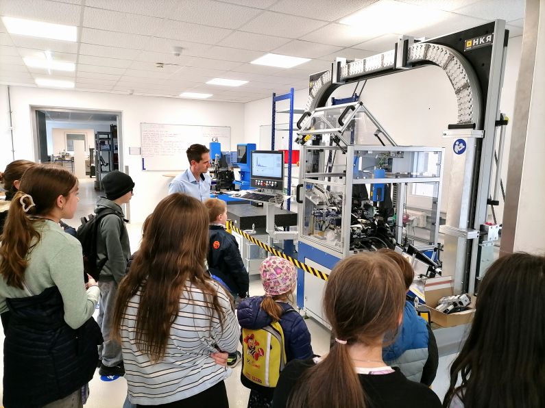 Kinder stehen vor einer Maschine.