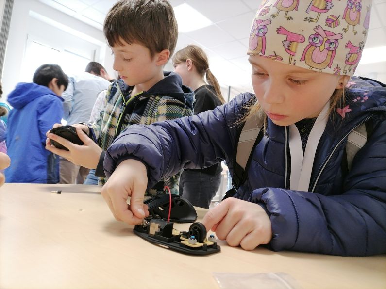 Zwei Kinder bauen Computermäuse zusammen