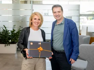 Daniela Zeiner hält einen Laptop in der Hand und posiert mit Markus Knasmüller für ein Foto